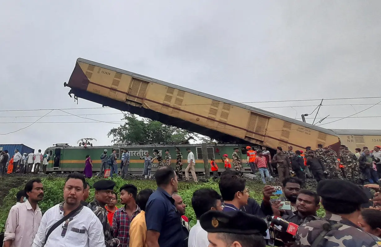 Rescue workers along with people gather at the site of a train collision after the accident in Darjeeling district in West Bengal state