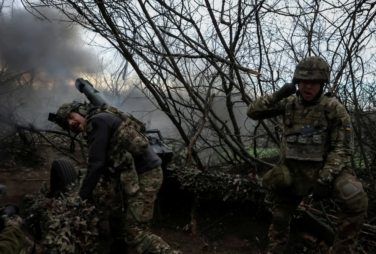 FILE PHOTO: Servicemen of the National Guard of Ukraine fire a howitzer towards Russian troops in Donetsk region