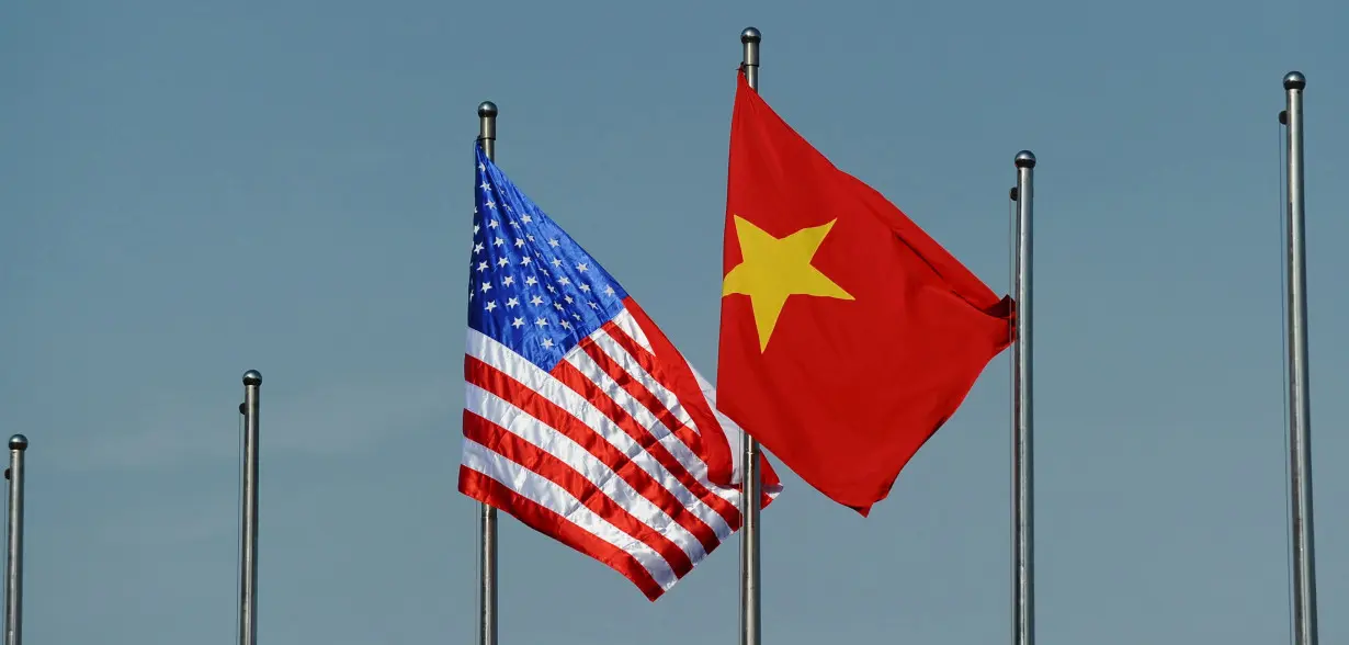 The U.S. flag flutters next to the Vietnamese flag during a welcoming ceremony for U.S. Defense Secretary Ash Carter in Hanoi, Vietnam