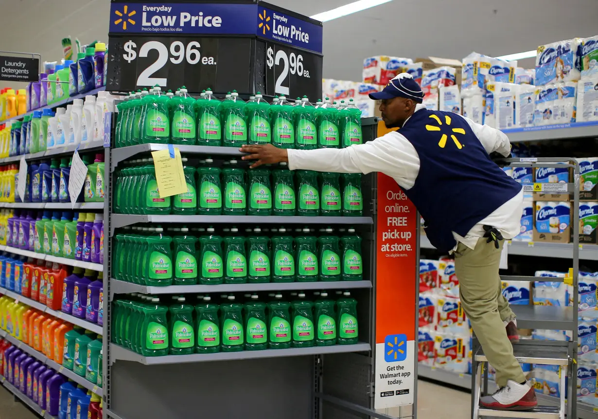 FILE PHOTO: A worker sets up a display of dish washing liquid in preparation for the opening of a Walmart Super Center in Compton, California