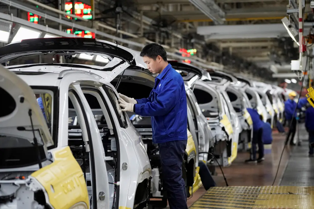 FILE PHOTO: Employees work on Baojun RS-5 cars at a final assembly plant operated by General Motors Co and its local joint-venture partners in Liuzhou