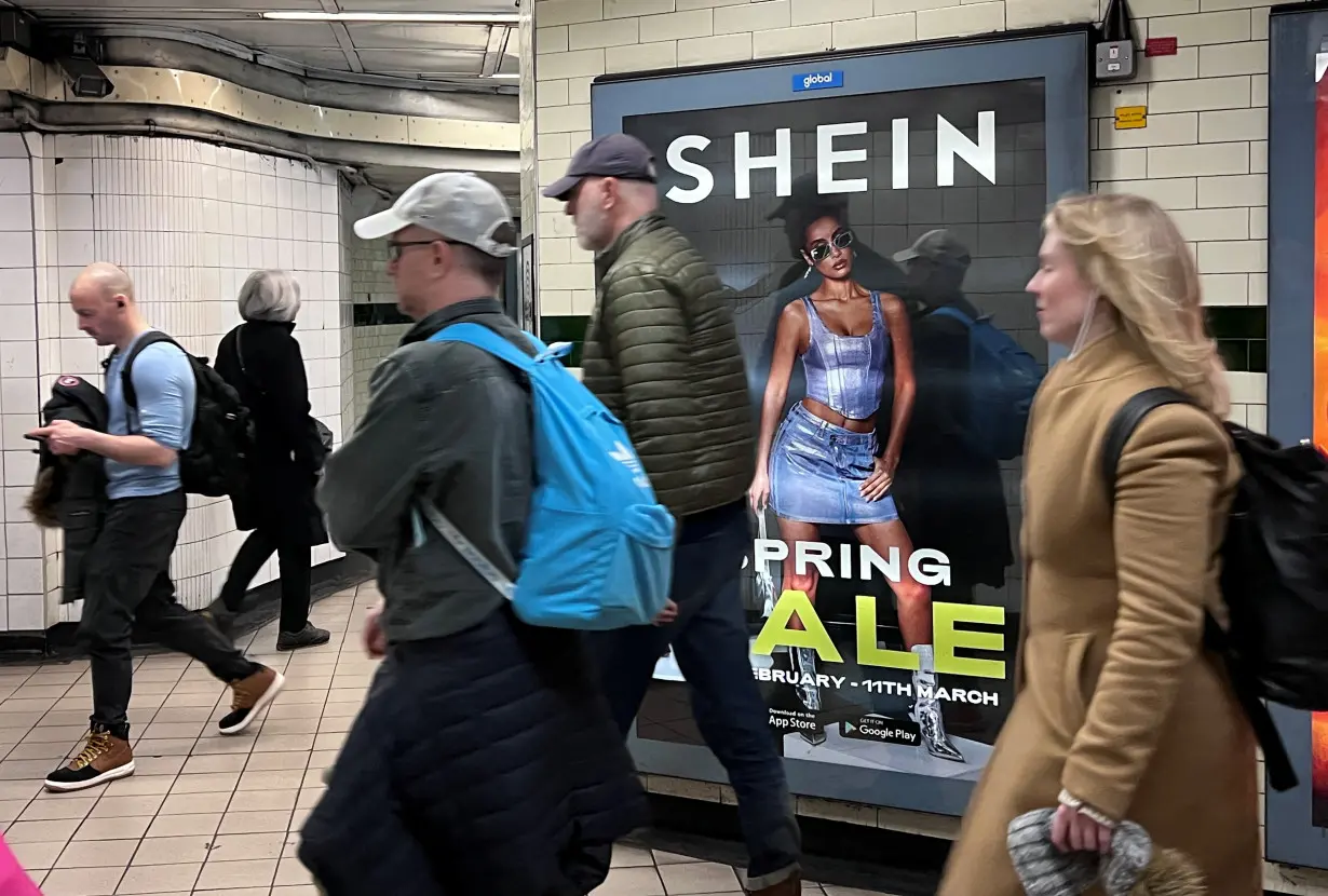 People walk past an advertisement for Shein