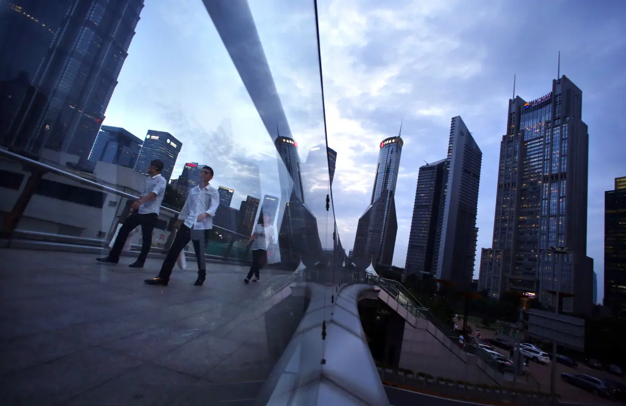 People cross a bridge at Pudong financial district in Shanghai