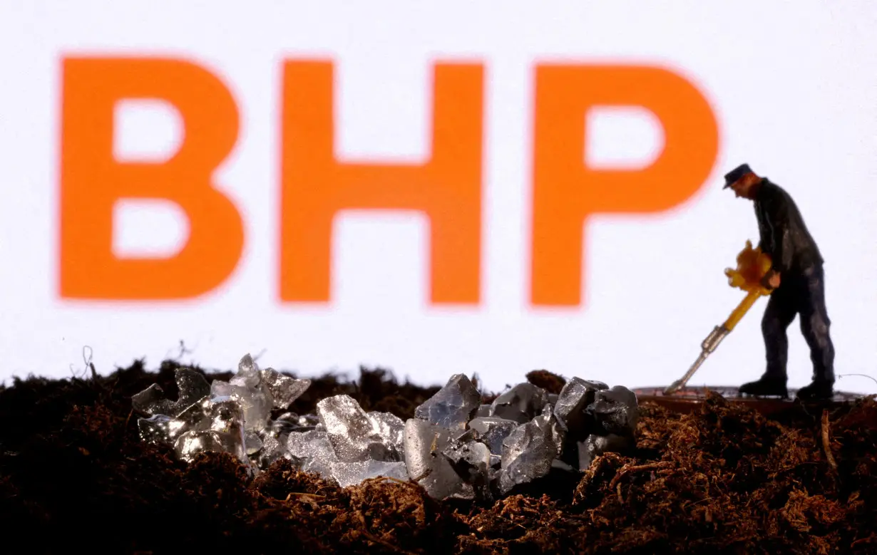 FILE PHOTO: Small toy figure and mineral imitation are seen in front of the BHP logo in this illustration