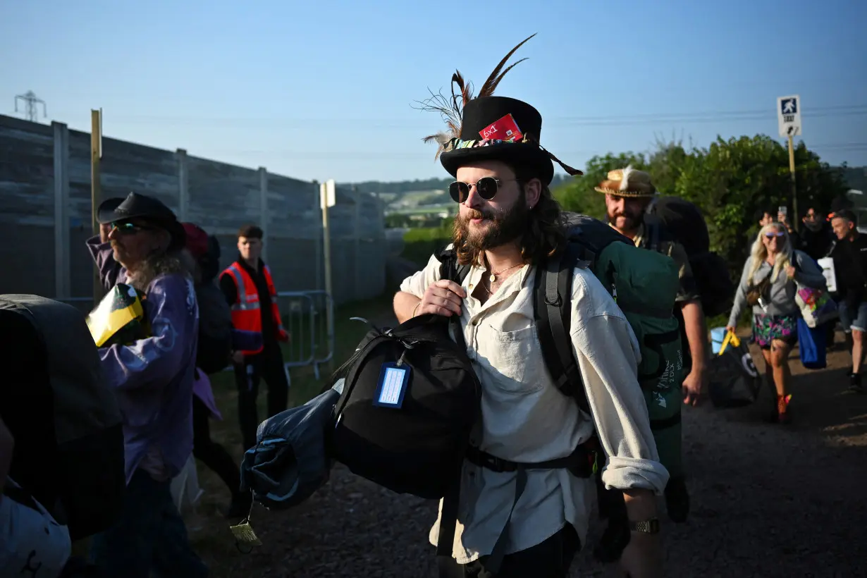 Revllers queue at Worthy Farm in Somerset during the Glastonbury Festival