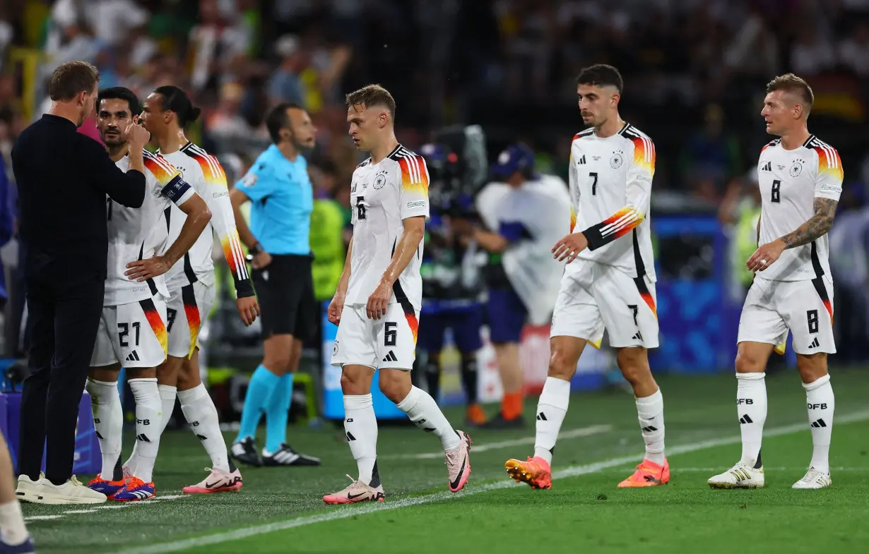 Germany players walk off the pitch after its game against Denmark was suspended due to lightning and heavy rain.