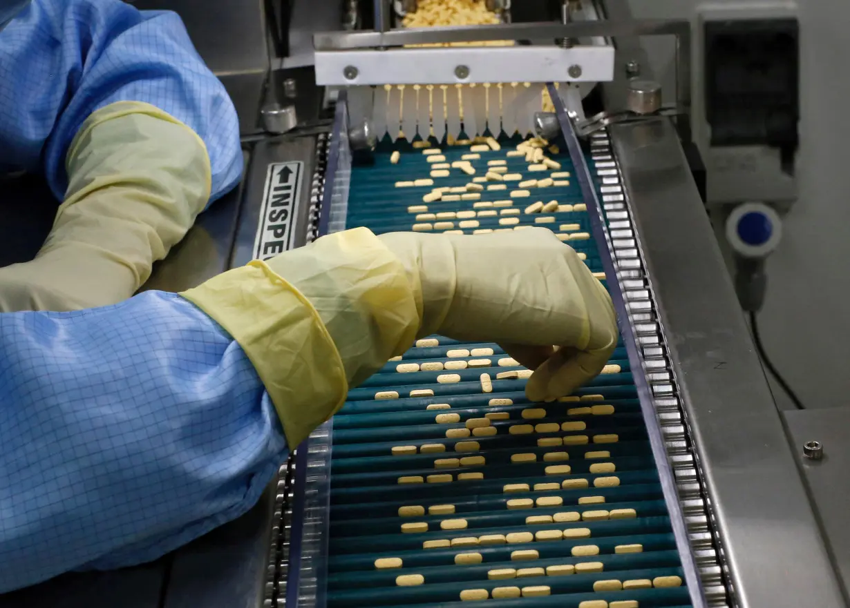 FILE PHOTO: An employee inspects tablets as they move along the production line at a pharmaceutical plant of Lupin, India's No. 2 drugmaker, in Verna