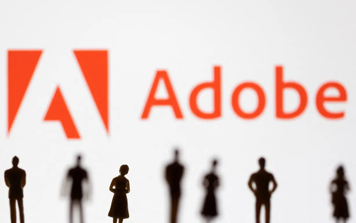 FILE PHOTO: Illustration shows figurines in front of Adobe logo