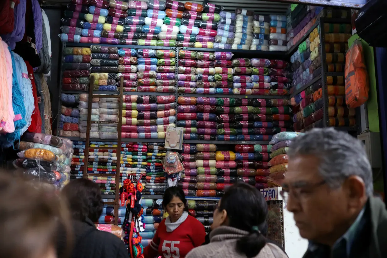 FILE PHOTO: A woman sells cloth trimmings at a stand at Surco market in Lima