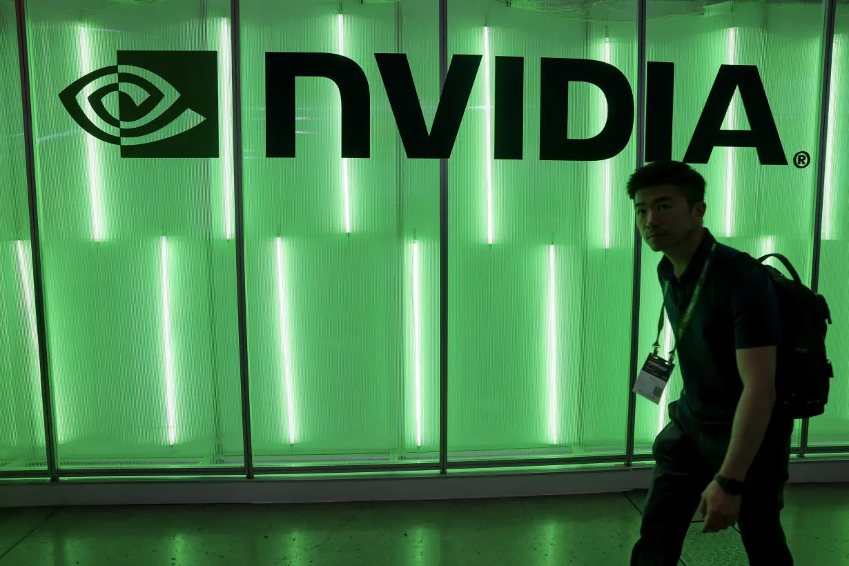 FILE PHOTO: A person walks pass a Nvidia logo at Computex in Taipei