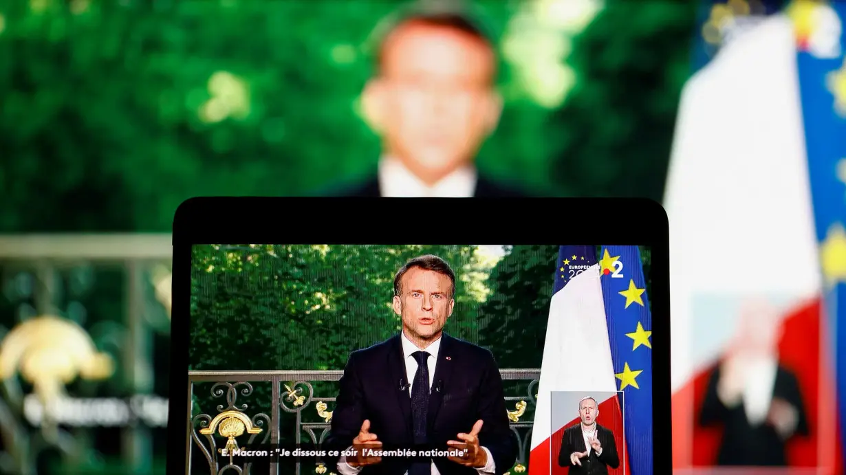 French President Emmanuel Macron appears on a screen as he delivers a speech following results after the polls closed in the European Parliament elections