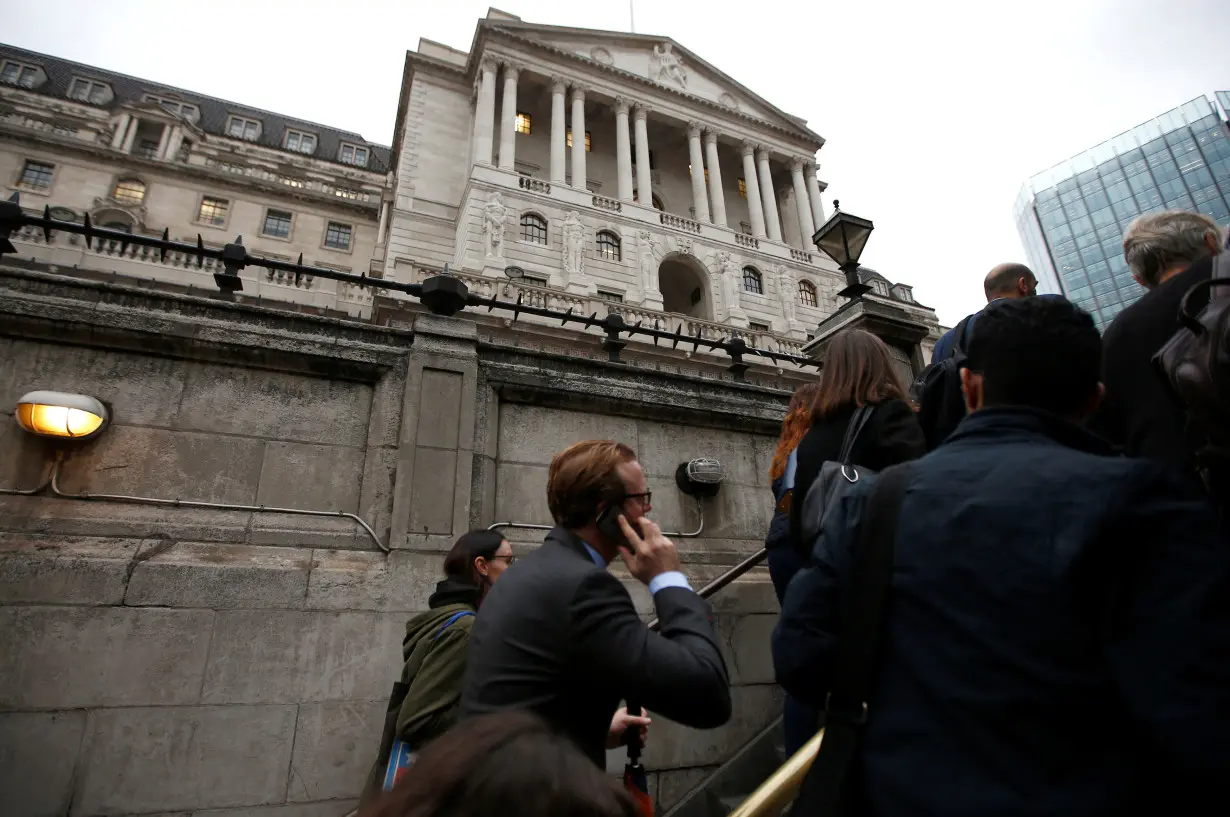 FILE PHOTO: Commuters exit the underground in front of the Bank of England in London