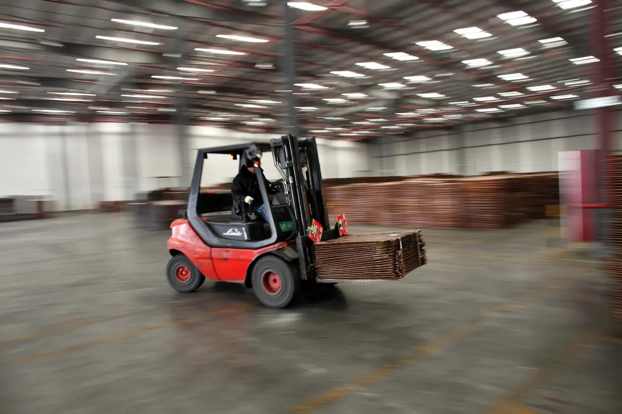 FILE PHOTO: A worker loads copper cathodes into a warehouse near Yangshan Deep Water Port