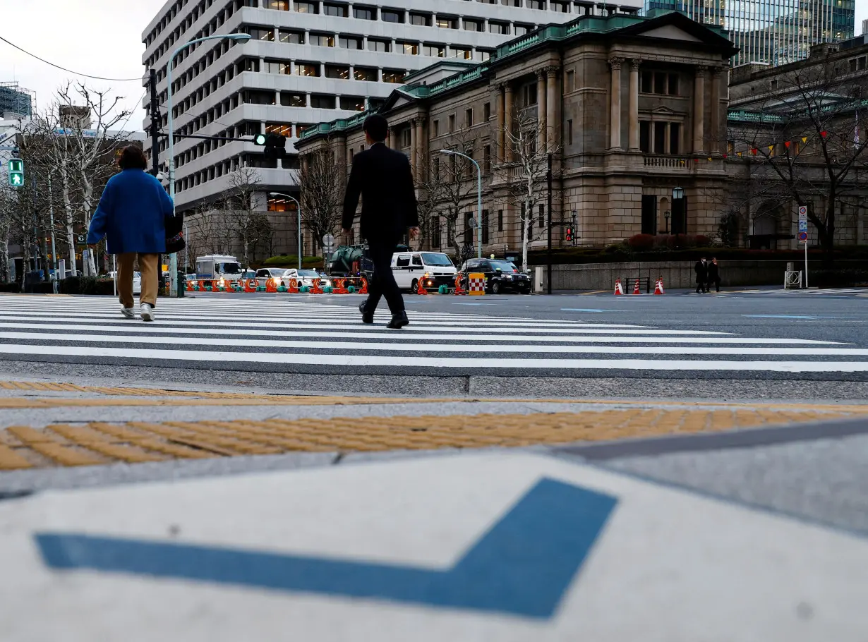 People walk in front of the Bank of Japan building in Tokyo