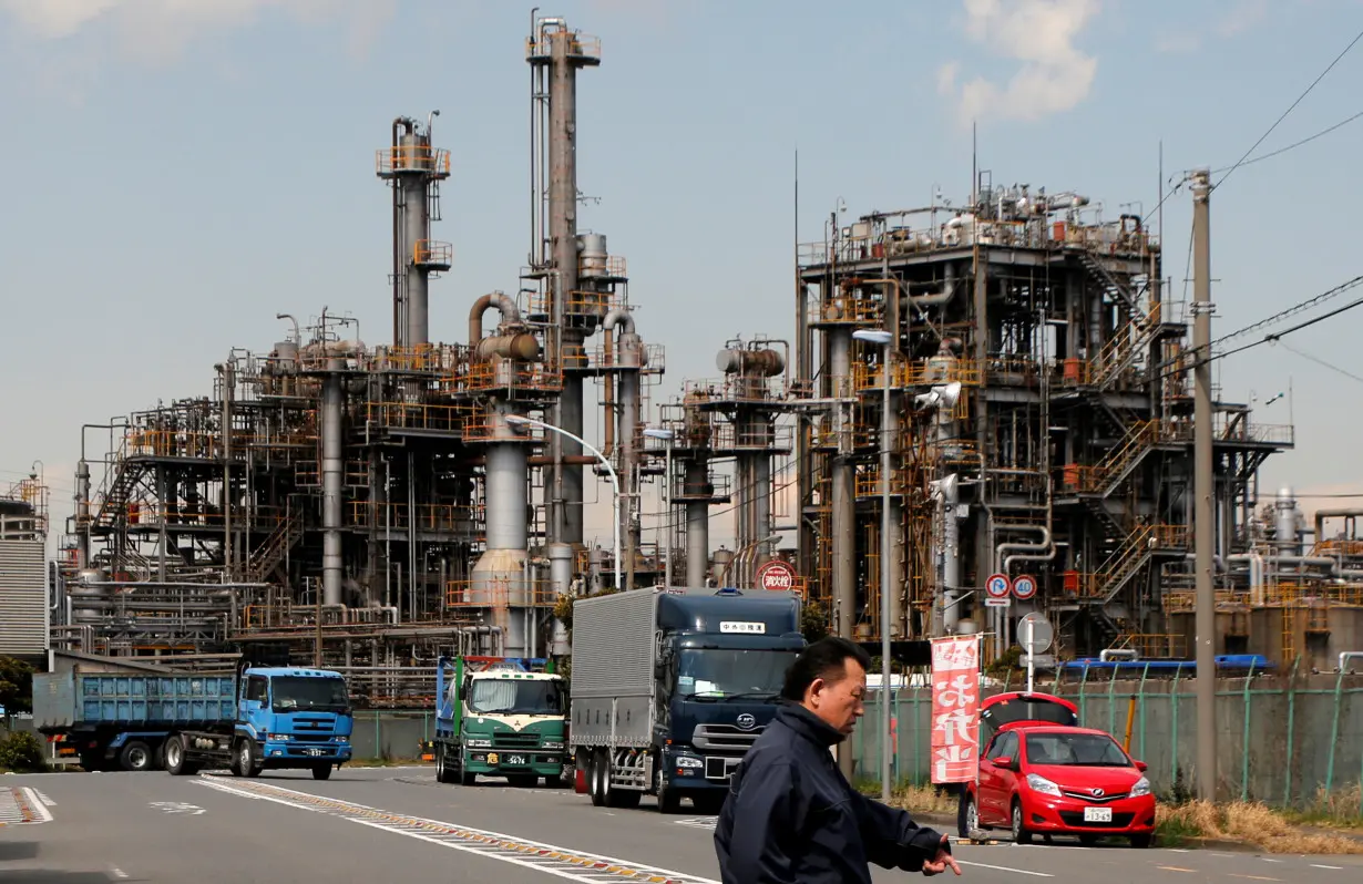 Worker walks near a factory at the Keihin industrial zone in Kawasaki