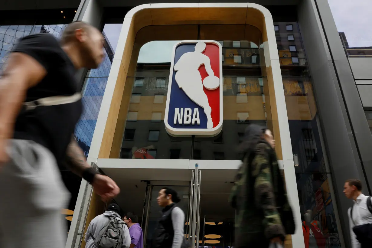 FILE PHOTO: The NBA logo is displayed as people pass by the NBA Store in New York