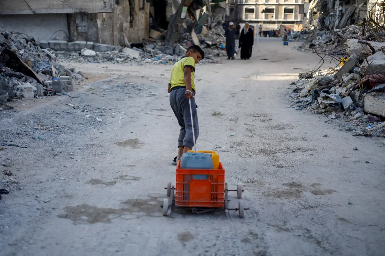 A Palestinian boy pulls water containers amid shortages, as the Israel-Hamas conflict continues, in Khan Younis in the southern Gaza Strip