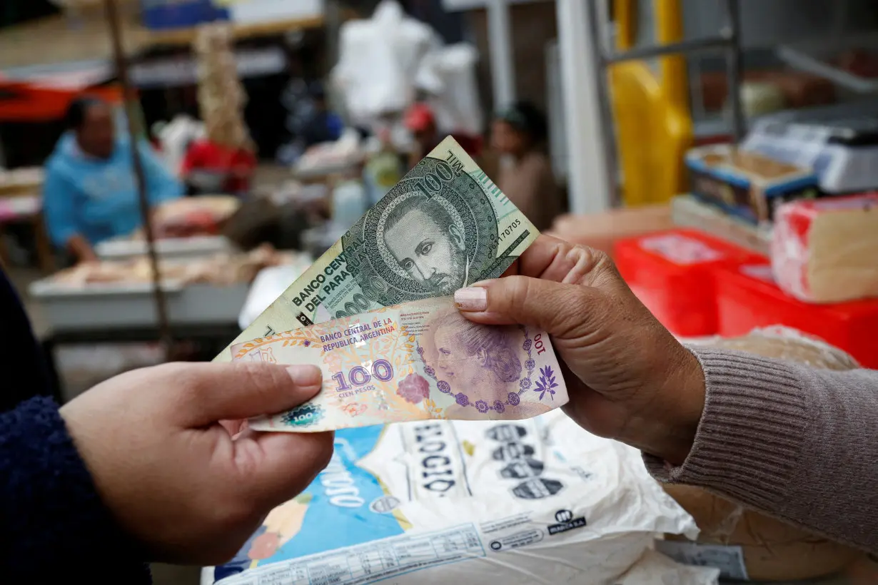 FILE PHOTO: Argentine and Paraguayan bills are shown at a market in Paraguay