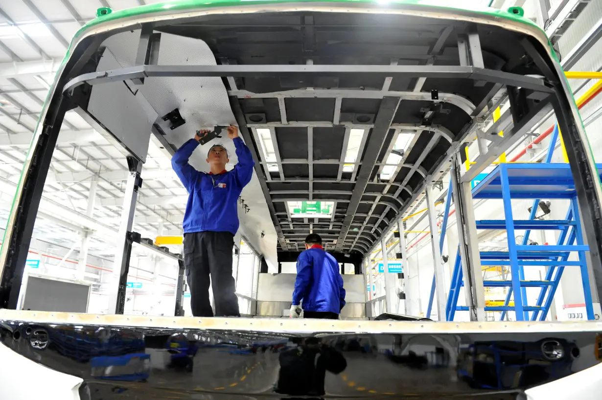 Workers assemble an electric bus at a BYD new energy vehicle (NEV) production base in Yinchuan