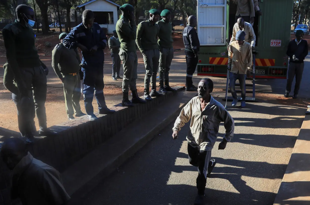 Opposition leader Jameson Timba walks after disembarking a prison truck as he arrives for bail application at the Harare Magistrates' court