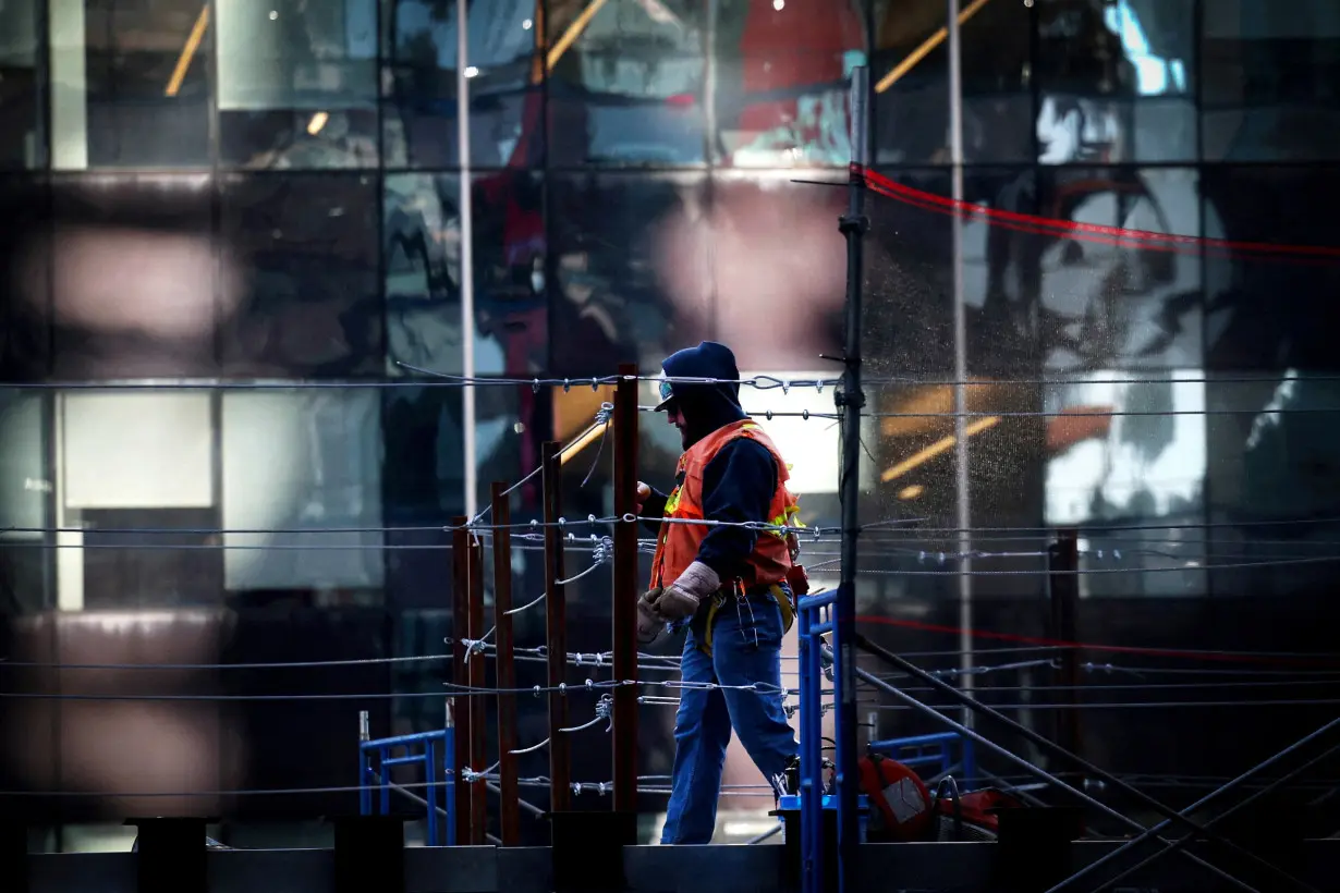 Construction worker cuts metal atop the One Times Square building which is being rebuilt for a new commercial real estate in New York City