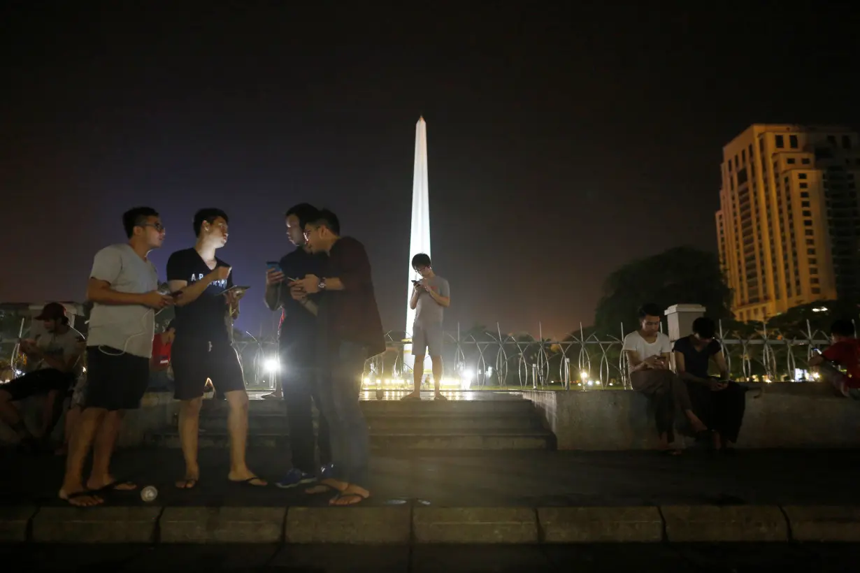 Youths play Pokemon Go in front of City Hall in central Yangon