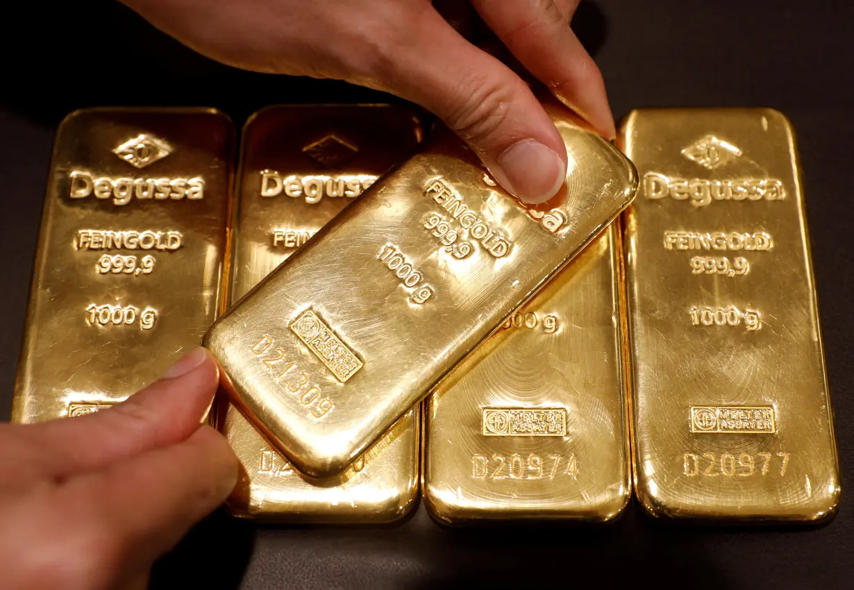 FILE PHOTO: An employee shows gold bullions at Degussa shop in Singapore