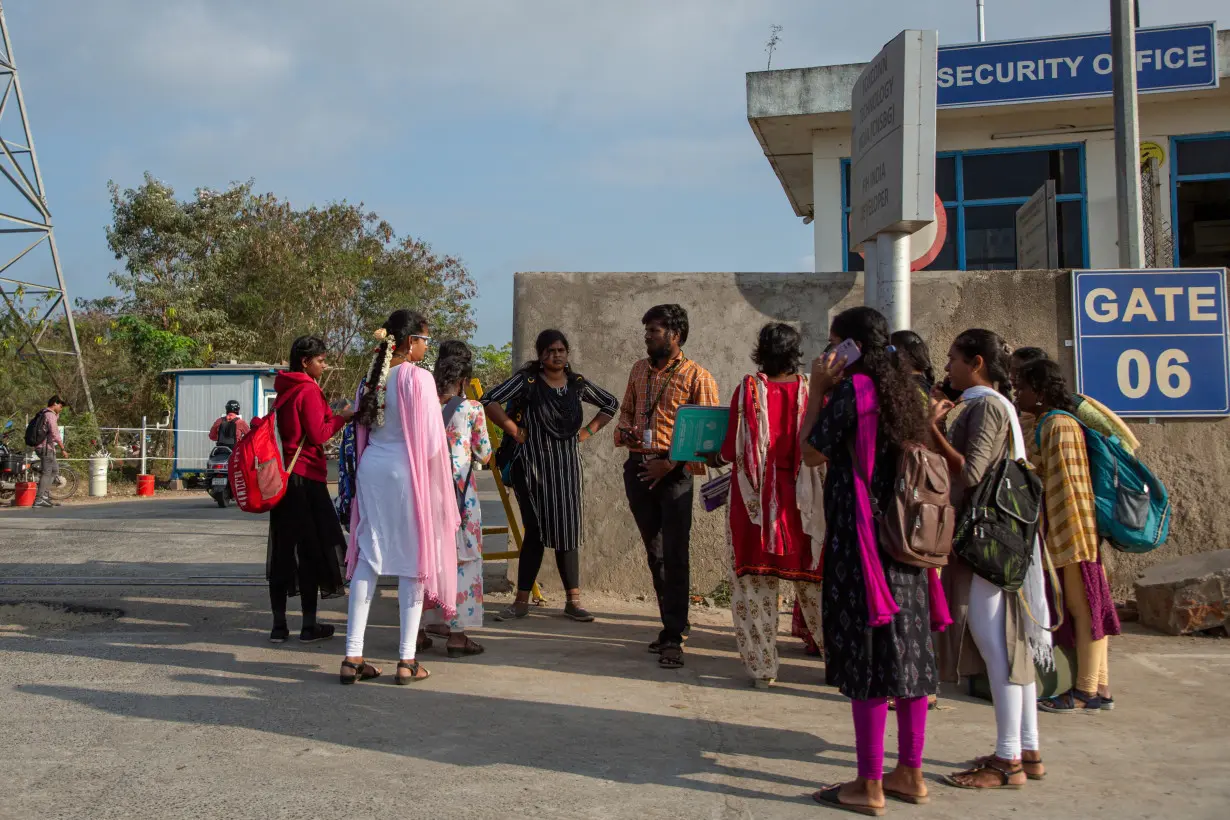 Job aspirants talk with a hiring agent outside the Foxconn plant in Sriperumbudur