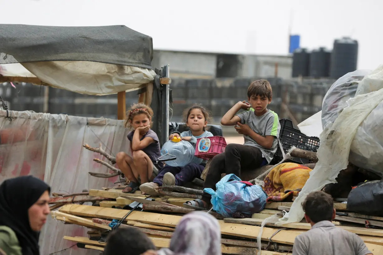 Palestinians travel on foot along with their belongings as they flee Rafah due to an Israeli military operation