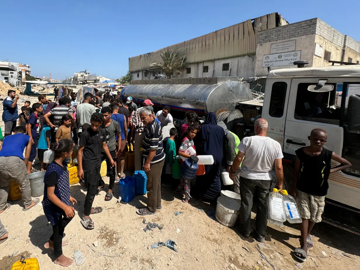 Palestinians gather to fill containers with water amid shortages as Israel-Hamas conflict continues, in Khan Younis in the southern Gaza Strip