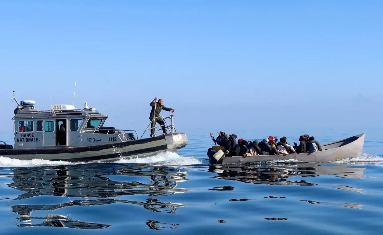 FILE PHOTO: Tunisian coast guards try to stop migrants at sea, off Sfax