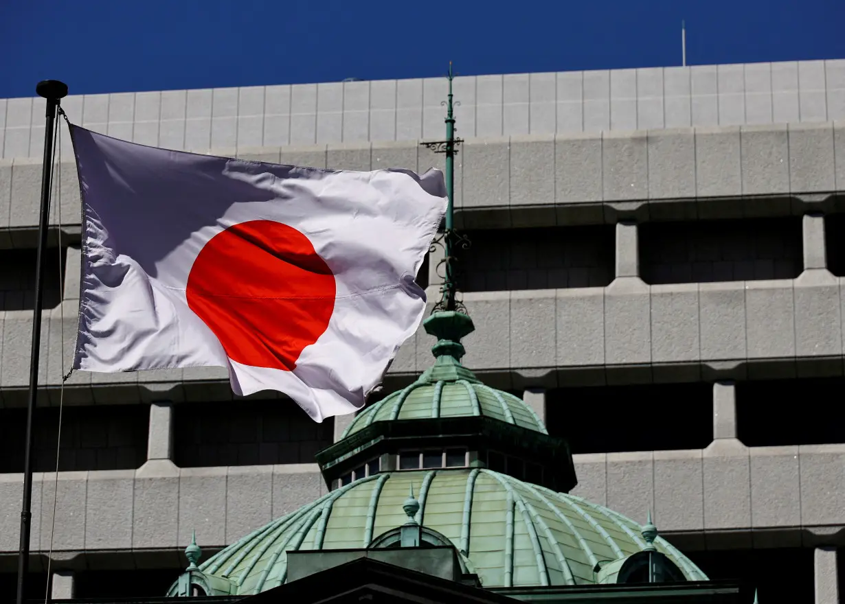 FILE PHOTO: Japanese national flag waves at the Bank of Japan building in Tokyo
