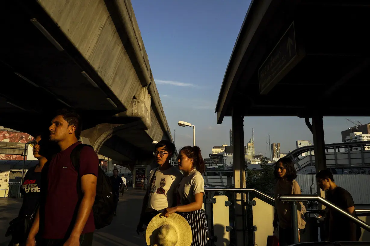 Tourists walk outside a shopping mall in Bangkok