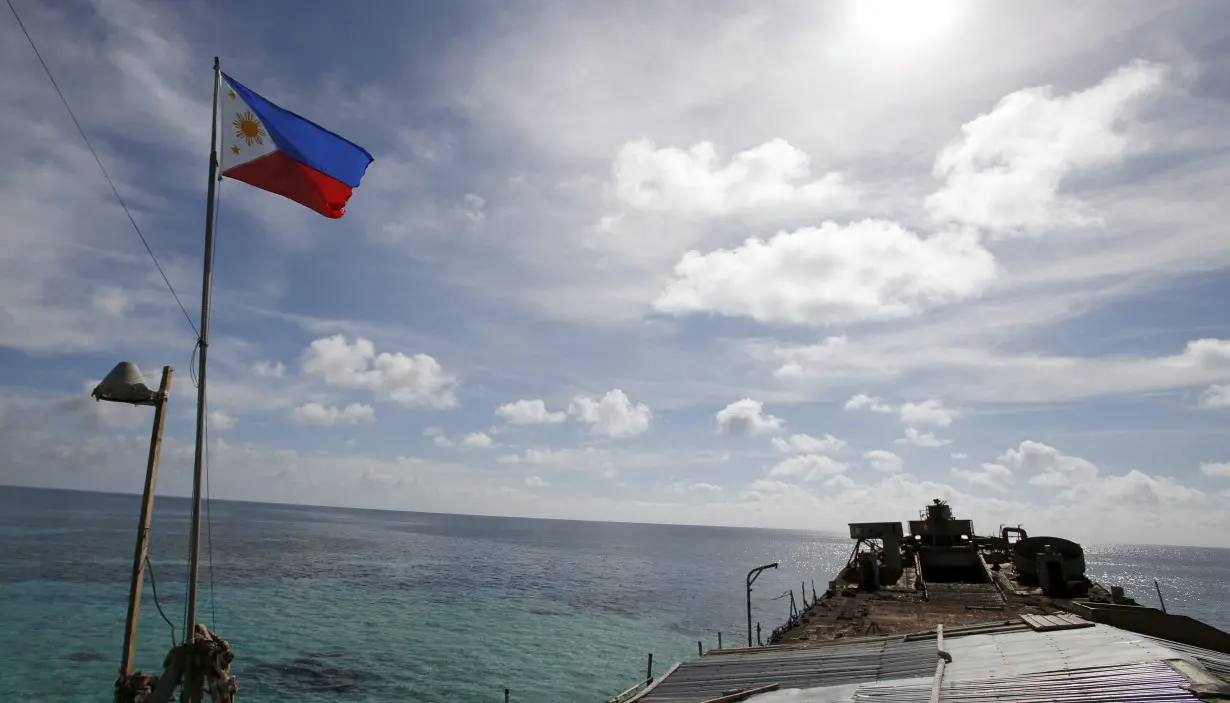 FILE PHOTO: A Philippine flutters on BRP Sierra Madre, a dilapidated Philippine Navy ship that has been aground since 1999, on the disputed Second Thomas Shoal, part of the Spratly Islands, in the South China Sea