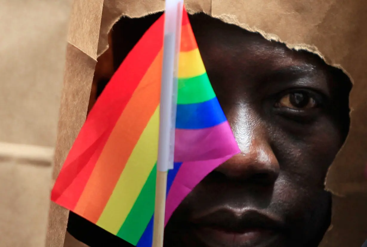 FILE PHOTO: An asylum seeker from Uganda covers his face with a paper bag in order to protect his identity as he marches with the LGBT Asylum Support Task Force during the Gay Pride Parade in Boston