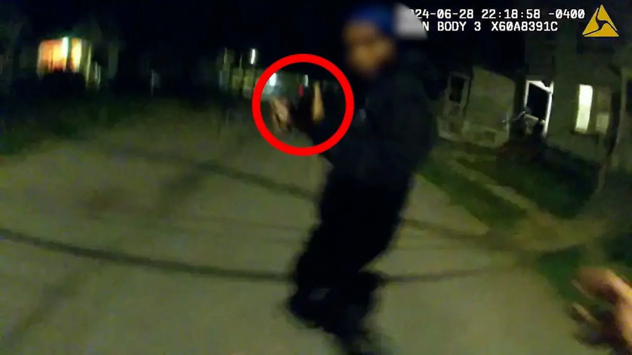 In this still image from body camera footage released by police in Utica, New York, Nyah Mway appears to point a replica gun at police officers. A red circle highlighting the replica gun was added by the police department.