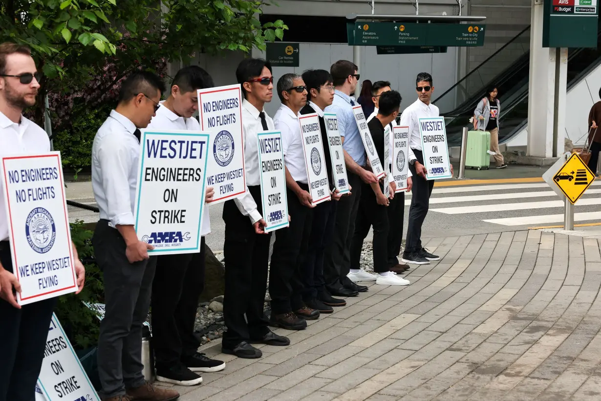Striking aircraft maintenance engineers and technical staff represented by the Aircraft Mechanics Fraternal Association union stand in a picket line against Westjet Airlines at Vancouver International Airport in Richmond, British Columbia, Canada June 29.