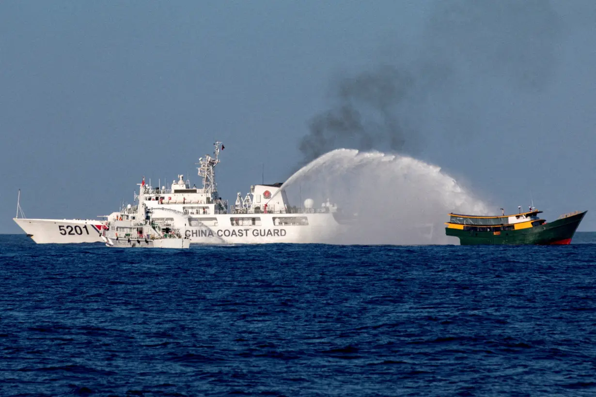 FILE PHOTO: FILE PHOTO: Chinese Coast Guard vessels fire water cannons towards a Philippine resupply vessel Unaizah May 4 as it made its way to the Second Thomas Shoal in the South China Sea