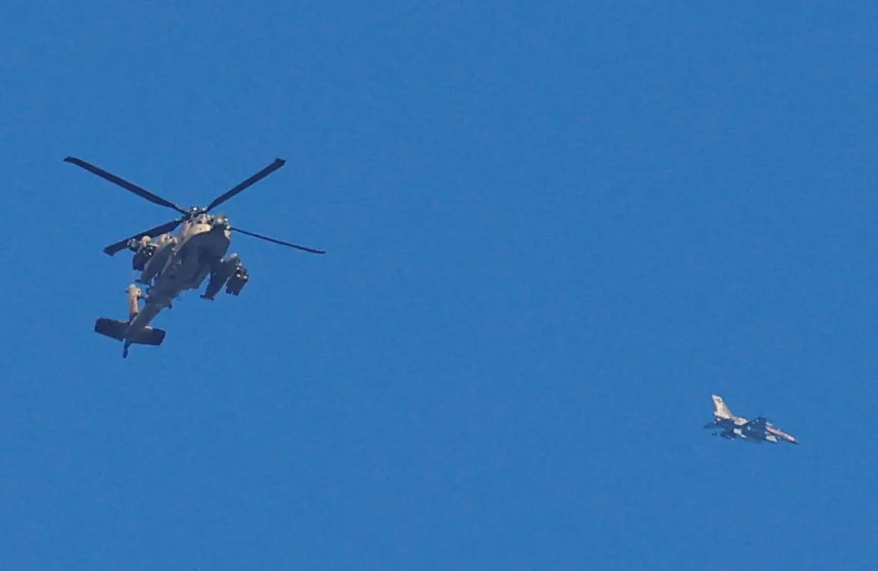 An Israeli military Apache helicopter and a jet fly close to the Gaza strip after a temporary truce between Israel and the Palestinian Islamist group Hamas expired, as seen from southern Israel