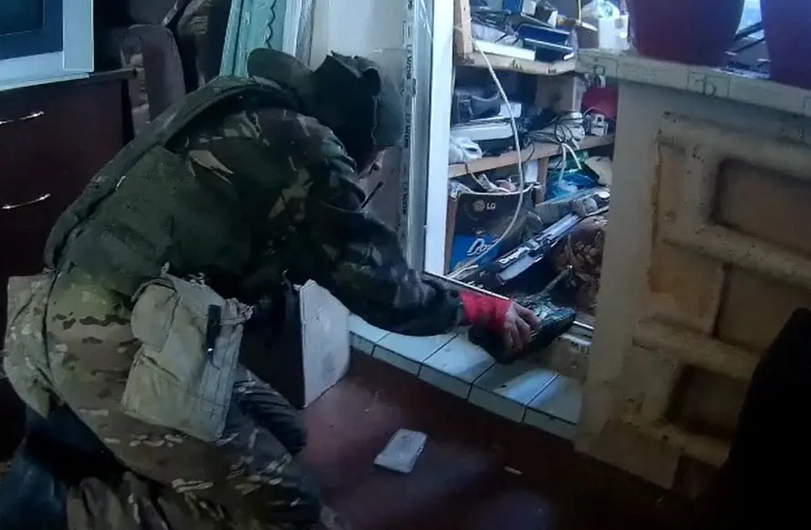 Screengrab from video footage obtained by Reuters shows a fighter from the BARS-09 volunteer force of the Russian military playing with a toy tank he found in an apartment in Balakliia