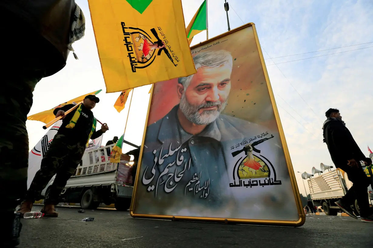 FILE PHOTO: Kataib Hezbollah Iraqi militia hold the picture of the Iranian Major-General Qassem Soleimani, as they gather ahead of the funeral of the Iraqi militia commander Abu Mahdi al-Muhandis, in Baghdad