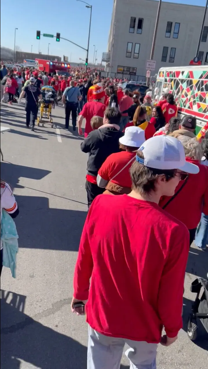 People leave a parade and an injured person is wheeled away on a stretcher by medical personnel following a shooting near an outdoor celebration of the NFL champion Chiefs' Super Bowl victory, in Kansas City