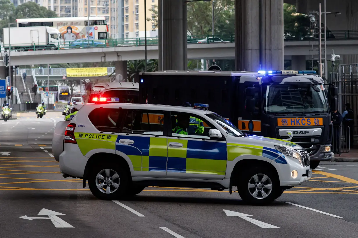 A police car is seen alongside the motorcade that carries media mogul Jimmy Lai, founder of Apple Daily, back to Lai Chi Kok Reception Centre after the first day of his national security trial in Hong Kong