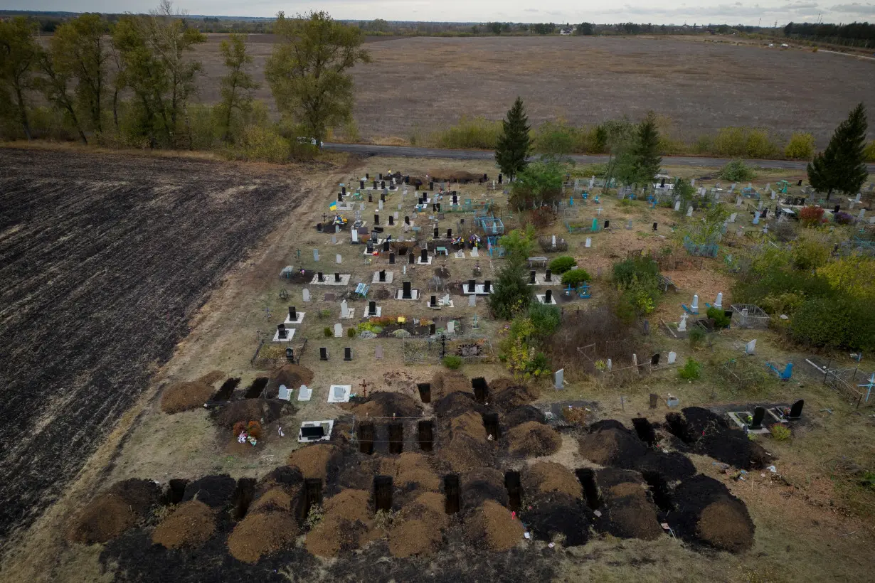 FILE PHOTO: An aerial picture shows freshly dug graves at the cemetery in the village of Hroza, near Kharkiv, where at least 52 people were killed in a missile attack amid Russia's ongoing attack on Ukraine