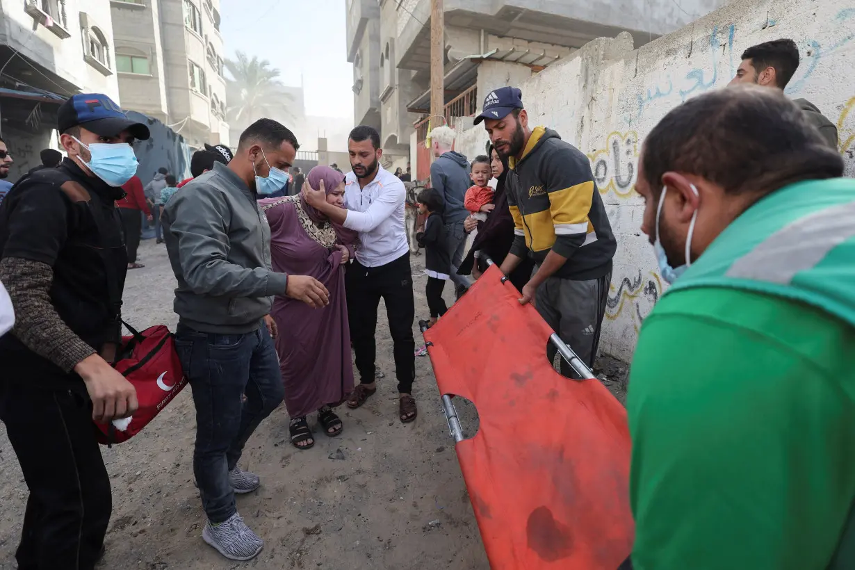 A Palestinian woman receives medical attention following an Israeli strike on a house in Rafah, amid the ongoing conflict between Israel and the Palestinian Islamist group Hamas, in the southern Gaza Strip