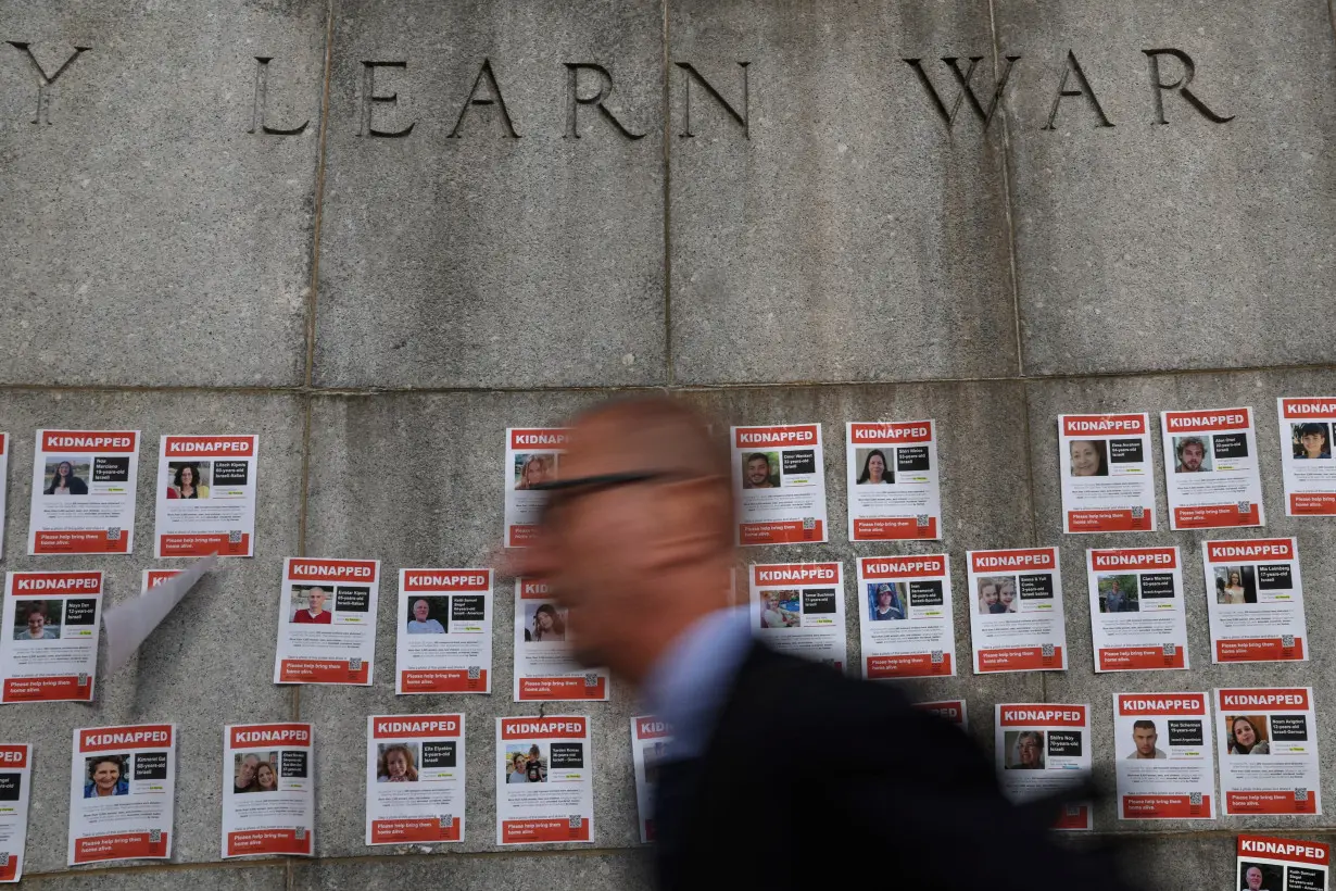 A man walks by pictures of hostages who are being held in Gaza, amid the ongoing conflict between Israel and Hamas, after a demonstration outside United Nations headquarters in New York City