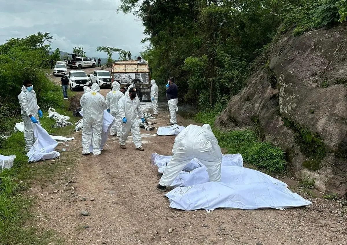 Forensic technicians work at a scene where authorities found several bodies linked to a gunfight between criminal gangs, in La Concordia