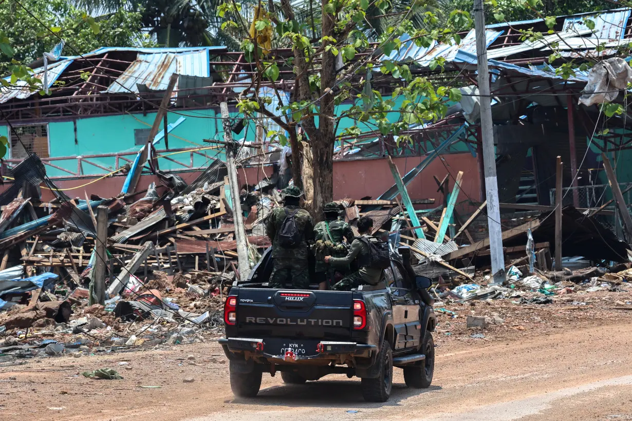 Soldiers from the Karen National Liberation Army (KNLA) patrol , next to an area destroyed by Myanmar's airstrike in Myawaddy, the Thailand-Myanmar border town under the control of a coalition of rebel forces led by the Karen National Union