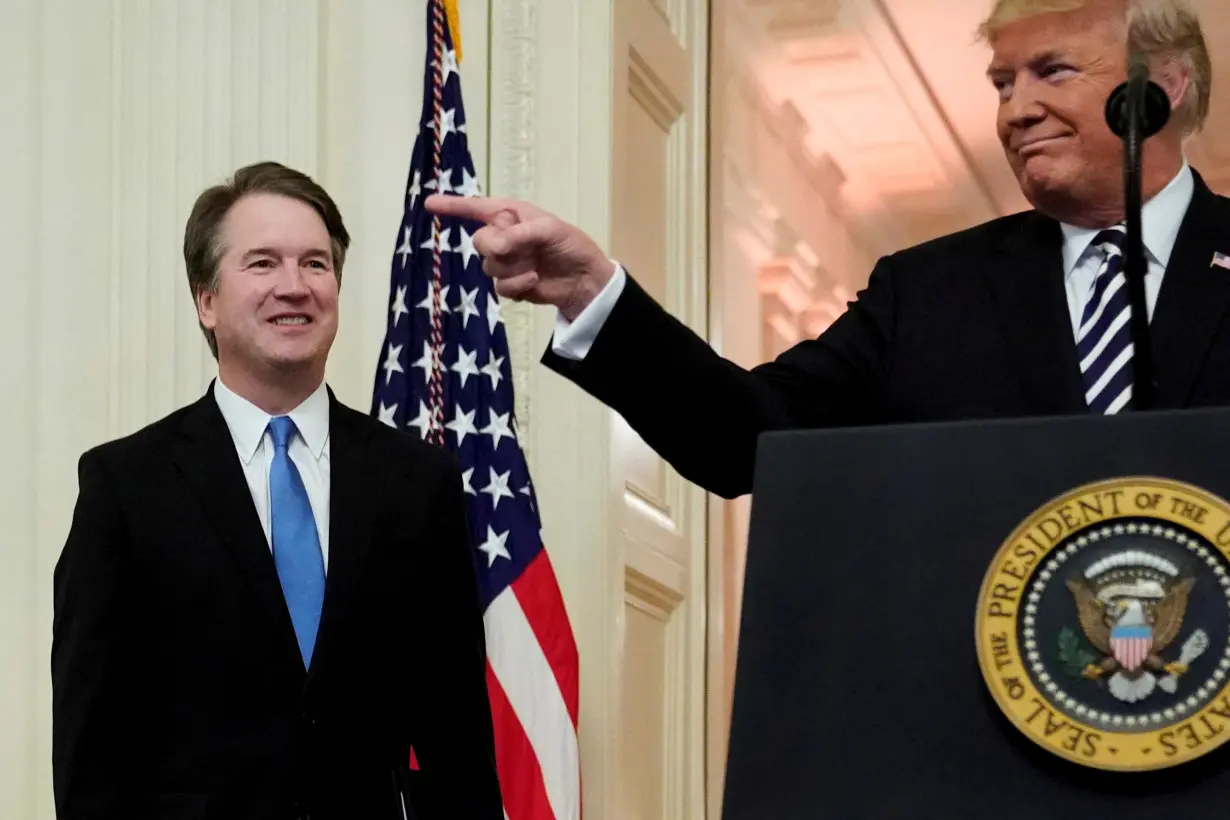 FILE PHOTO: U.S. President Donald Trump speaks next to U.S. Supreme Court Associate Justice Brett Kavanaugh as they participate in a ceremonial public swearing-in at the East Room of the White House in Washington