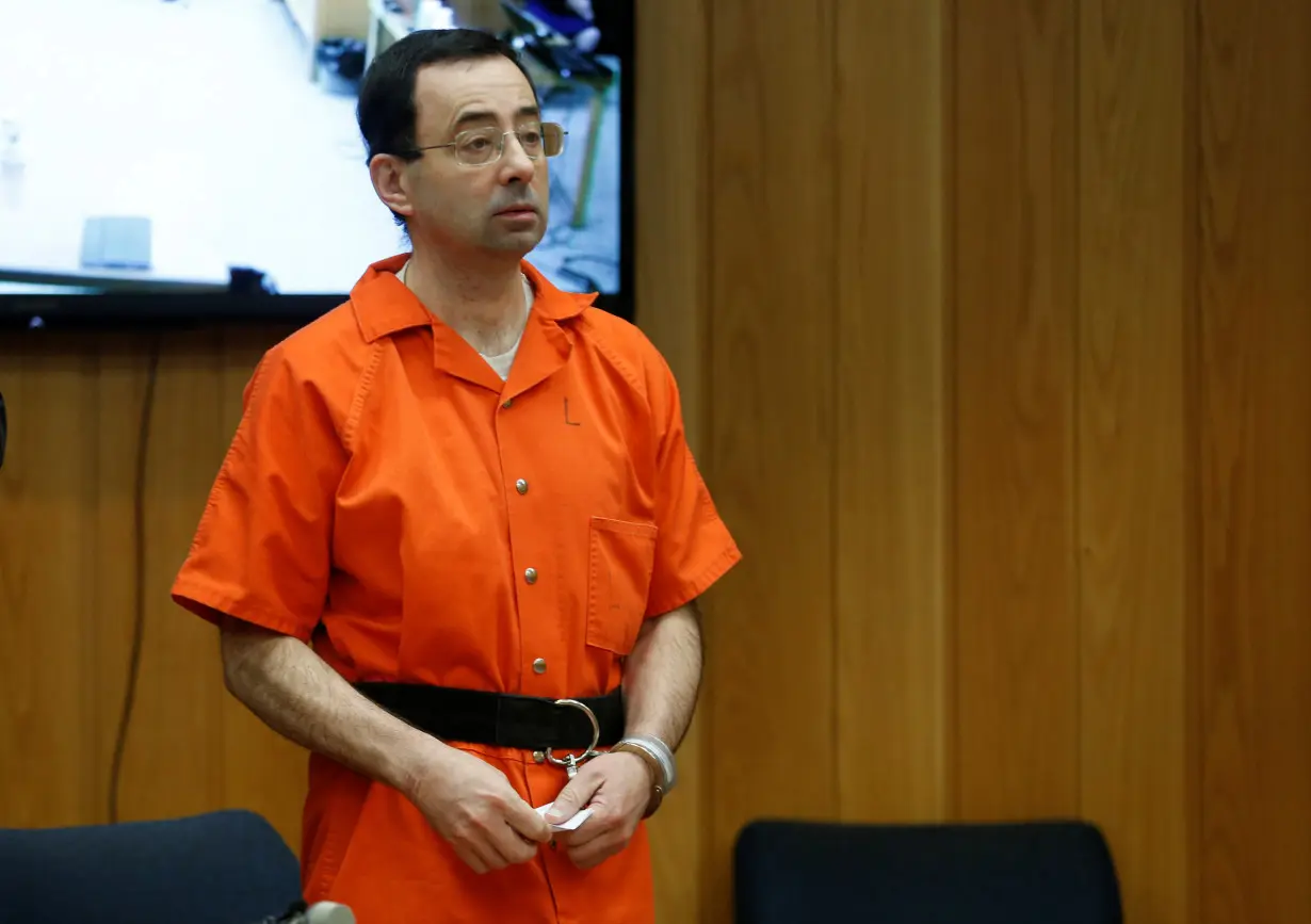 FILE PHOTO: Larry Nassar, a former team USA Gymnastics doctor who pleaded guilty in November 2017 to sexual assault charges, stands in court during his sentencing hearing in the Eaton County Court in Charlotte